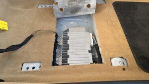 低音用スピーカーから音が出ない不具合の原因究明と対処を実施前の、ポルシェケイマン(981型)運転席下の純正アンプ